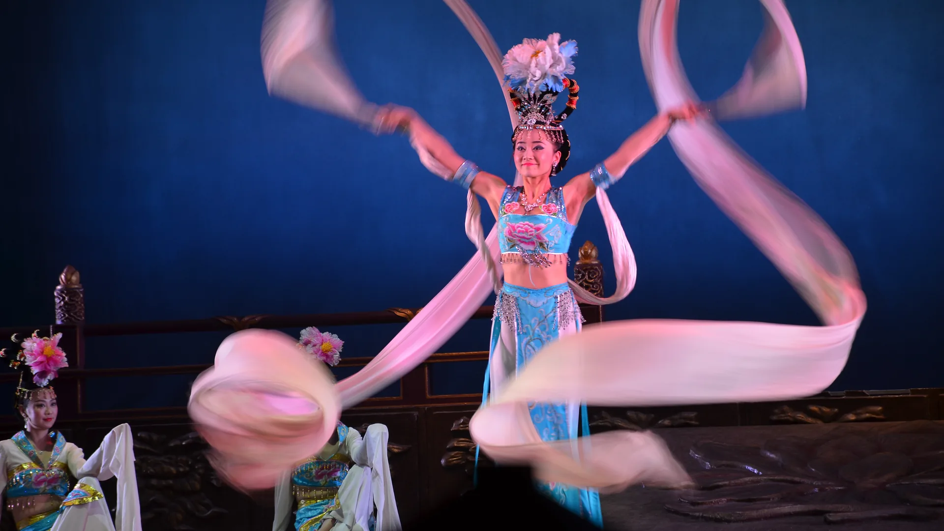 Chinese classical dancers in flowing long-sleeved silk costumes on a stage